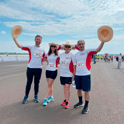 4 Menschen in Laufkleidung vor blauem Himmel