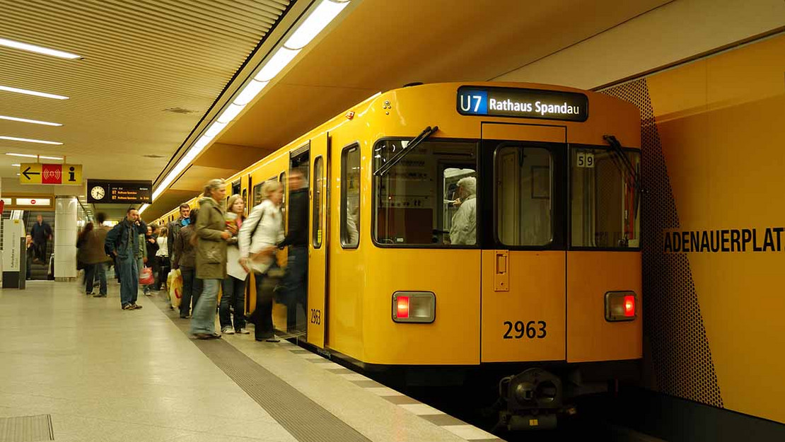 Menschen steigen in einem Berliner U-Bahnhof in eine Bahn. 