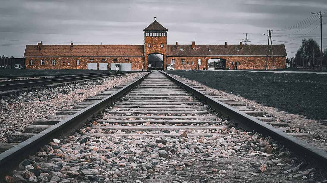 Gleise führen zum Eingangstor vom Konzentrationslager Auschwitz. 