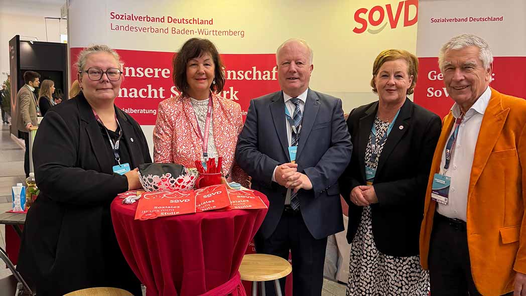 Männer und Frauen stehen am Messetisch