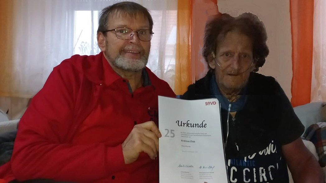 Zwei Männer mit Urkunde.